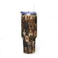 A tall insulated tumbler with a clear lid and straw, featuring an all-over print of various dog faces in tan, brown, black, and cream tones. The tumbler is shown on a clean white background.